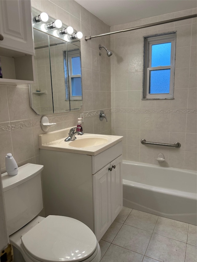 full bathroom featuring toilet, tiled shower / bath, tile walls, tile patterned floors, and vanity