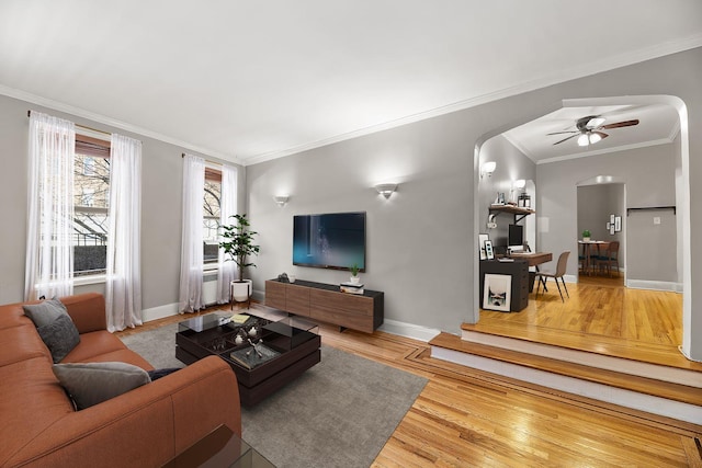 living room with hardwood / wood-style floors, ceiling fan, and crown molding