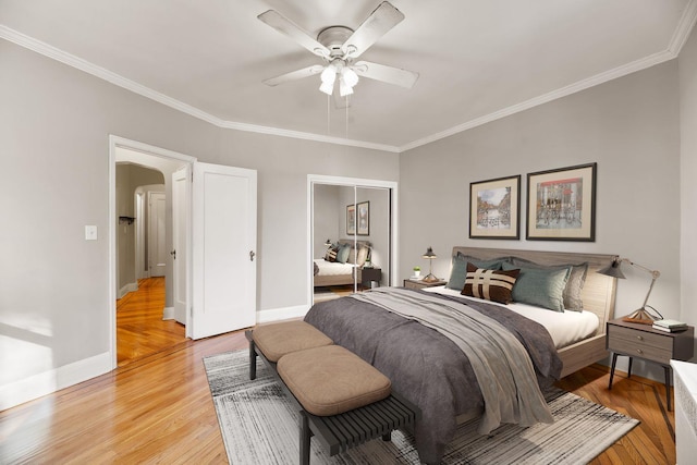 bedroom featuring crown molding, ceiling fan, a closet, and light hardwood / wood-style floors