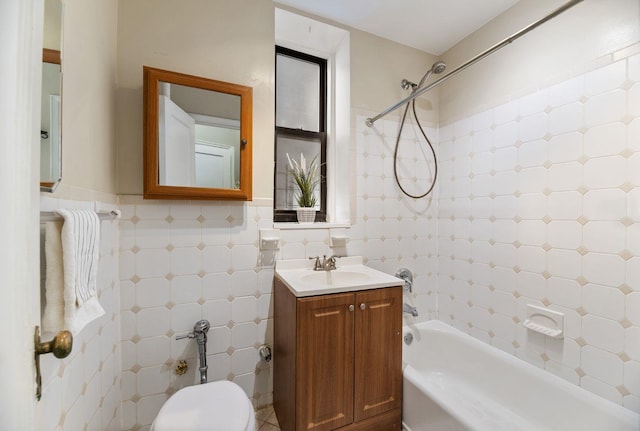 full bathroom featuring toilet, vanity, tile walls, and tiled shower / bath