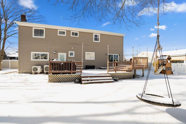 snow covered property with a trampoline, a wooden deck, ac unit, and a playground