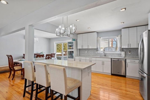 kitchen featuring white cabinetry, backsplash, a kitchen island, and appliances with stainless steel finishes