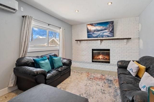 living room with a brick fireplace and a wall unit AC