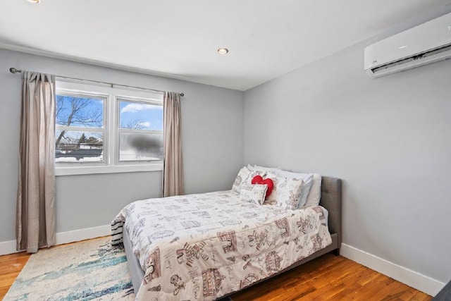 bedroom featuring wood-type flooring and a wall mounted AC