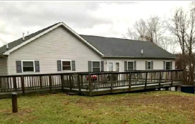 back of property with a yard and a wooden deck