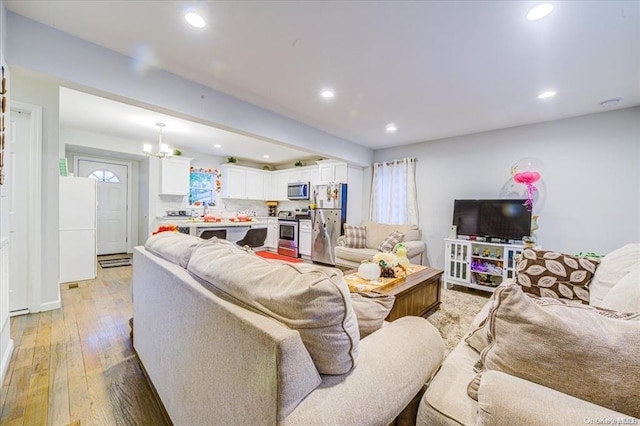 living room featuring a chandelier and light wood-type flooring