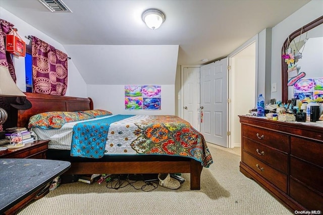 bedroom with light colored carpet and vaulted ceiling