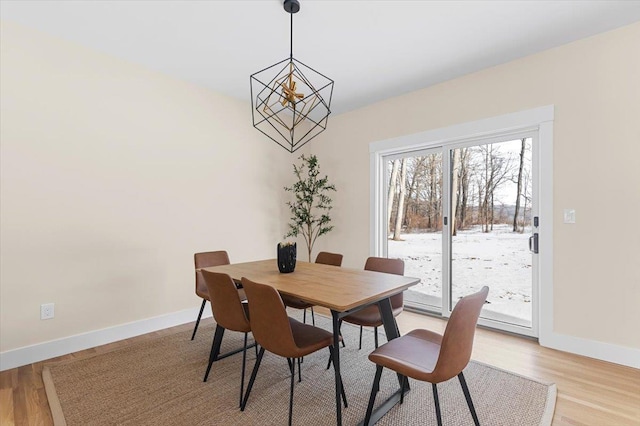 dining space featuring a notable chandelier and light hardwood / wood-style floors