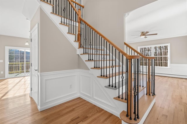 stairway featuring ceiling fan and wood-type flooring