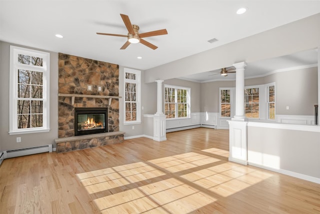 unfurnished living room with ceiling fan, a baseboard radiator, light hardwood / wood-style flooring, decorative columns, and a fireplace