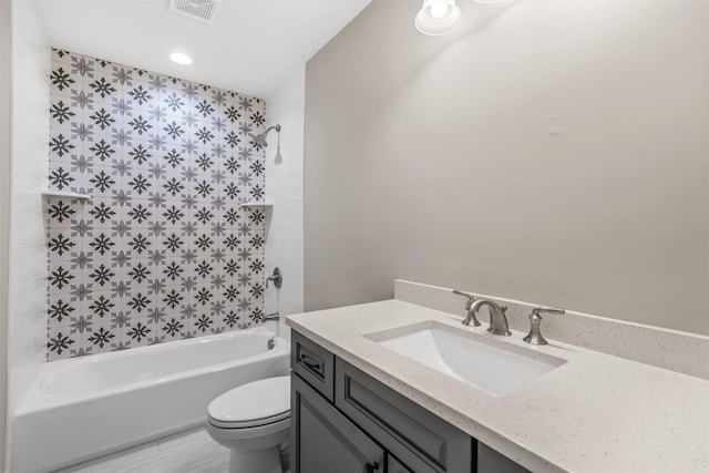 full bathroom with tiled shower / bath, vanity, and toilet