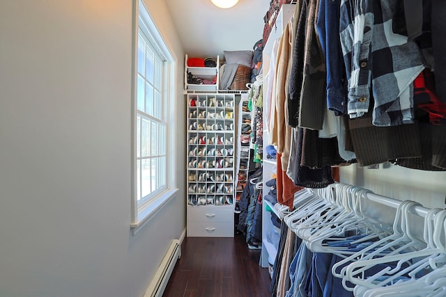 spacious closet featuring a baseboard heating unit and dark hardwood / wood-style floors