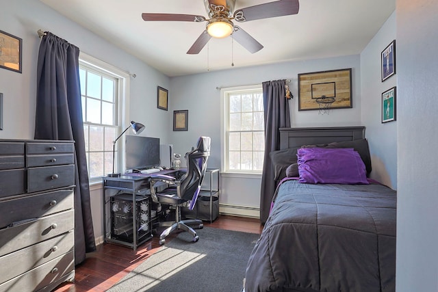 bedroom with ceiling fan, a baseboard radiator, multiple windows, and dark hardwood / wood-style floors