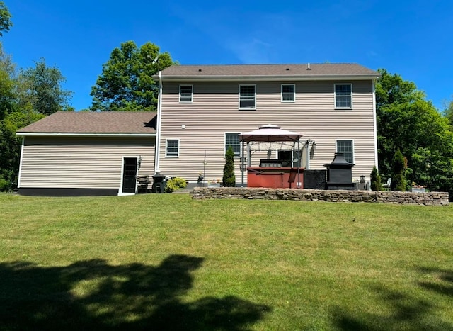 back of house featuring a gazebo, a hot tub, and a yard