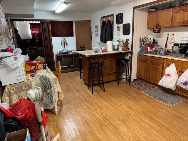 kitchen featuring light wood-type flooring and a breakfast bar area