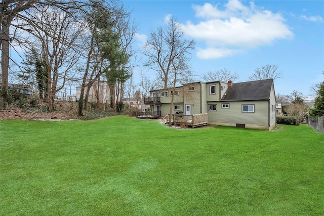 rear view of property featuring a lawn and a wooden deck