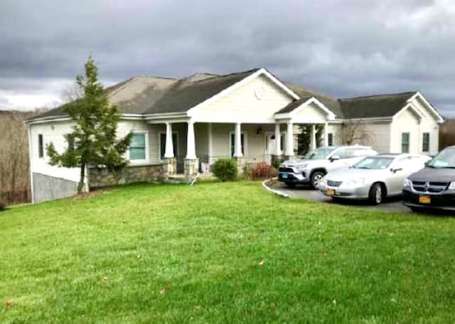 view of front of home with covered porch and a front lawn