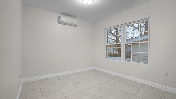 unfurnished room featuring a wall mounted AC and light tile patterned floors