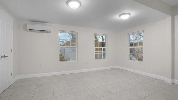 tiled empty room featuring a wall unit AC