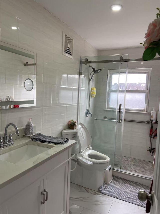 bathroom featuring vanity, toilet, an enclosed shower, and tile walls