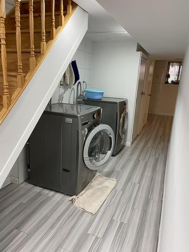 laundry room featuring washing machine and clothes dryer and light wood-type flooring