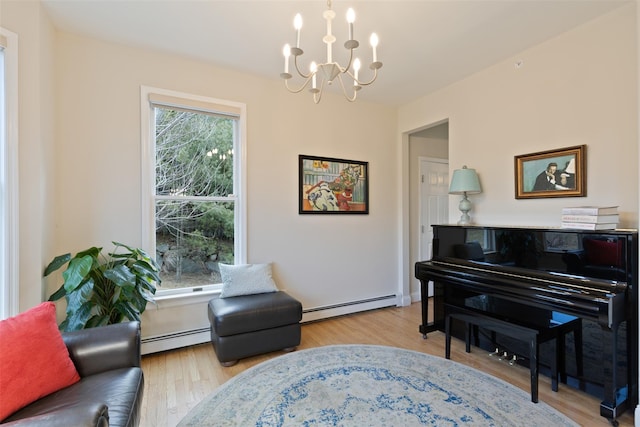 sitting room featuring a chandelier, baseboard heating, and wood finished floors