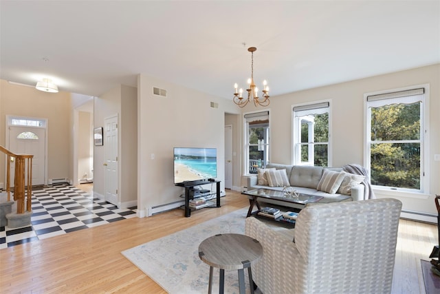 living area with visible vents, an inviting chandelier, stairs, a baseboard heating unit, and baseboard heating