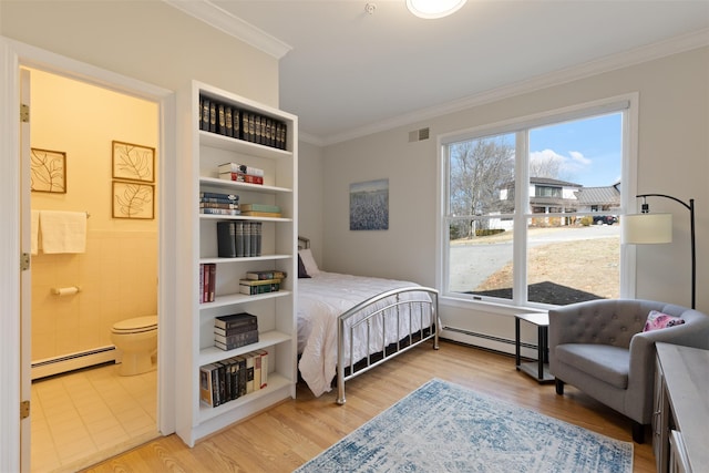 bedroom featuring baseboard heating, crown molding, visible vents, and wood finished floors