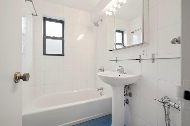 bathroom featuring tile walls, tasteful backsplash, tile patterned floors, and washtub / shower combination