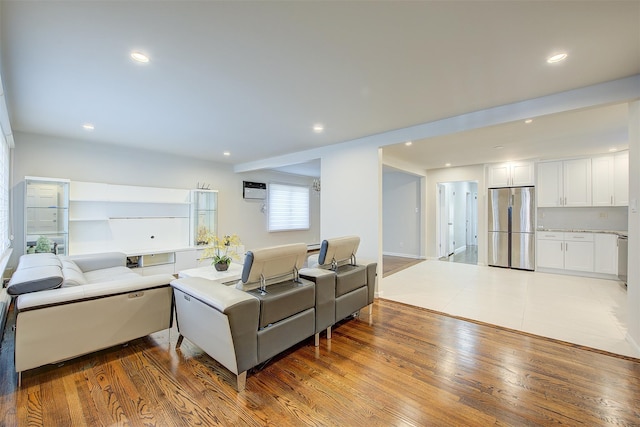 living room featuring hardwood / wood-style flooring and a wall mounted AC