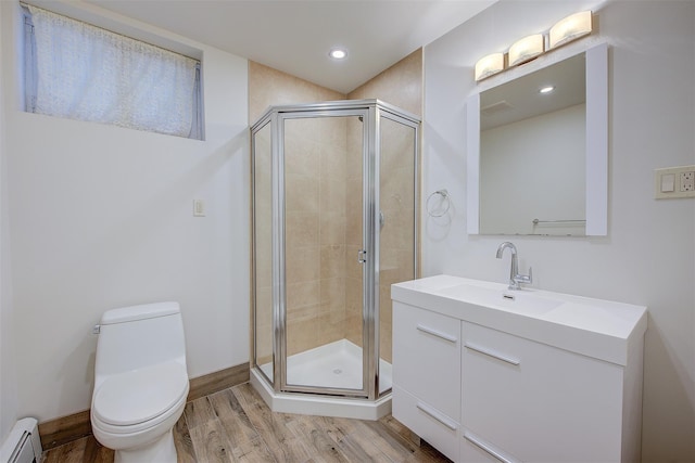 bathroom with toilet, a baseboard heating unit, a shower with door, and hardwood / wood-style flooring