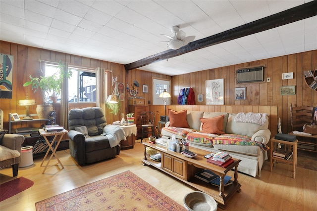 living room with ceiling fan, beamed ceiling, wood walls, and light hardwood / wood-style floors