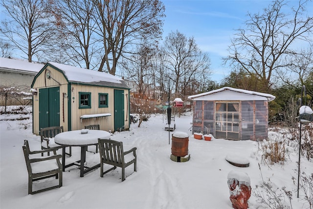 yard covered in snow featuring a storage unit