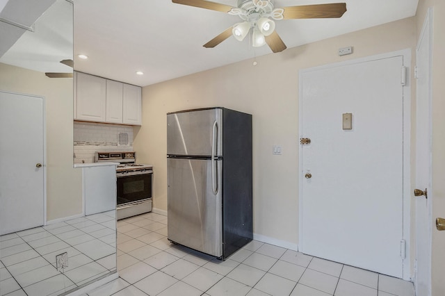 kitchen with light tile patterned flooring, tasteful backsplash, stainless steel refrigerator, white range with gas cooktop, and white cabinets