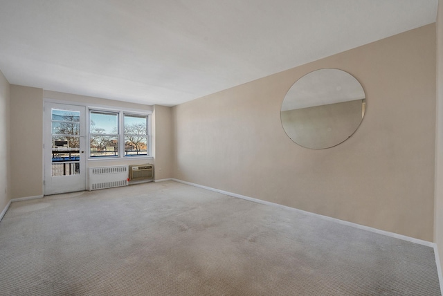 unfurnished room with a wall mounted air conditioner, radiator, and light colored carpet