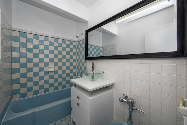 bathroom with tasteful backsplash, tiled shower / bath, sink, and tile walls