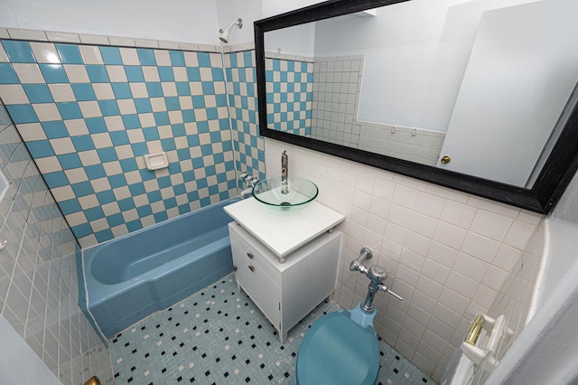 full bathroom with tile patterned floors, toilet, tile walls, shower / bathtub combination, and vanity