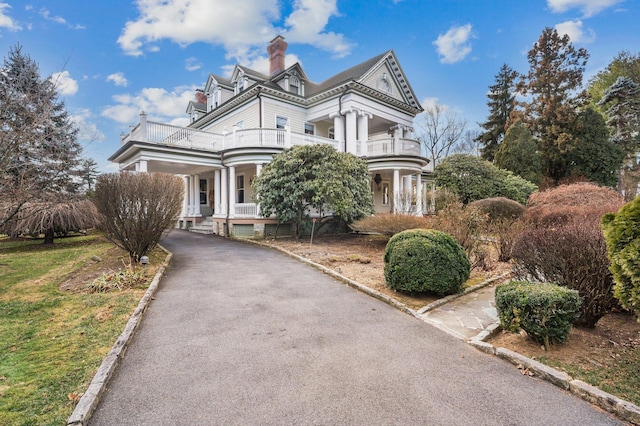 neoclassical / greek revival house featuring a porch and a balcony