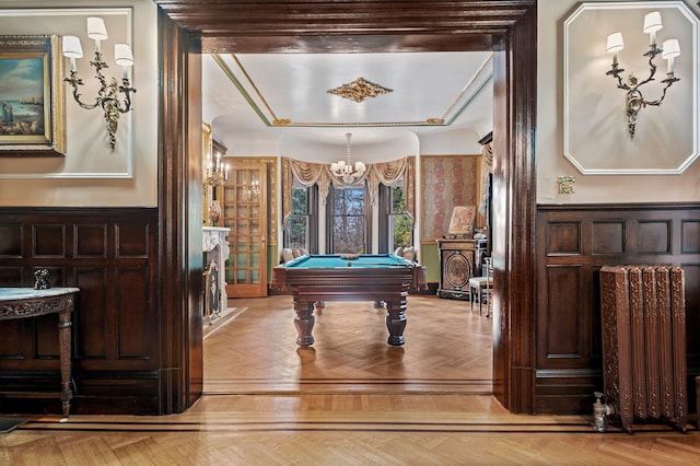 recreation room featuring radiator, light parquet floors, pool table, and an inviting chandelier