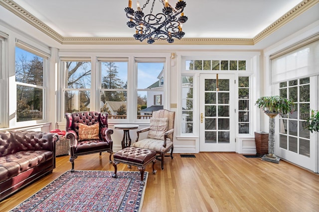 sunroom featuring a wealth of natural light and a notable chandelier