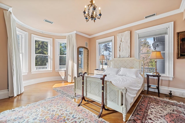 bedroom with a notable chandelier, crown molding, light hardwood / wood-style flooring, and multiple windows