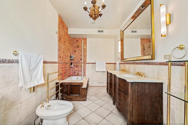 bathroom with tile patterned floors, vanity, a tub, tile walls, and a bidet