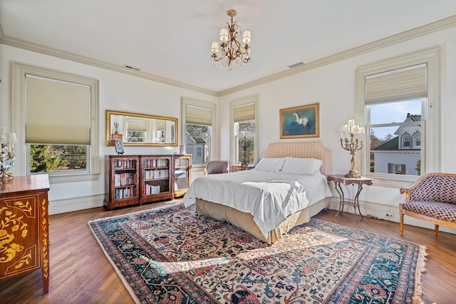 bedroom with ornamental molding, hardwood / wood-style floors, and multiple windows