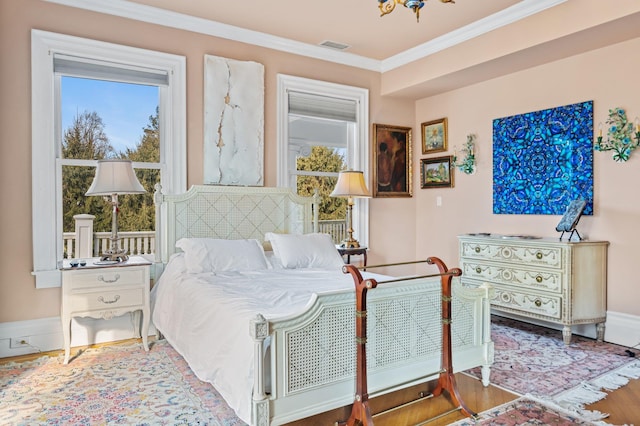 bedroom featuring ornamental molding and hardwood / wood-style floors