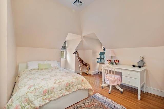 bedroom with vaulted ceiling and light hardwood / wood-style flooring