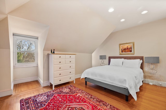 bedroom with vaulted ceiling and hardwood / wood-style floors