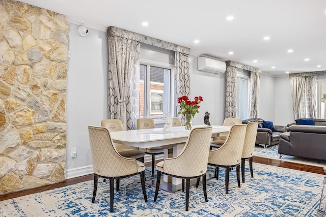 dining space with a wall mounted air conditioner, crown molding, and hardwood / wood-style floors