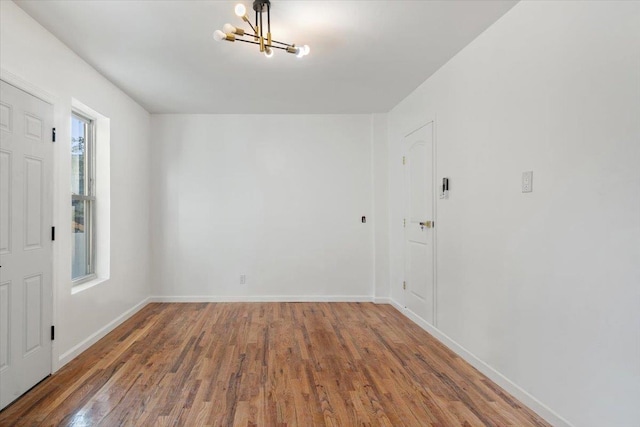 unfurnished room featuring dark hardwood / wood-style flooring and a notable chandelier