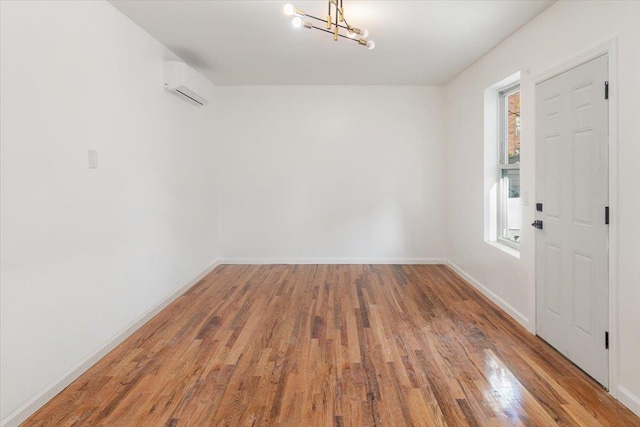 foyer with hardwood / wood-style floors, a notable chandelier, and an AC wall unit