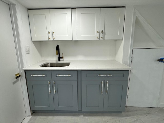 kitchen with gray cabinetry, white cabinetry, and sink